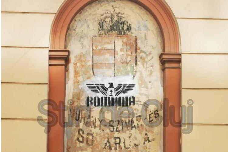 Stema maghiară de pe o clădire din Cluj, vandalizată în urmă cu un an, este la fel și acum. Vulturul asemănător unui simbol INTERZIS nu a fost șters