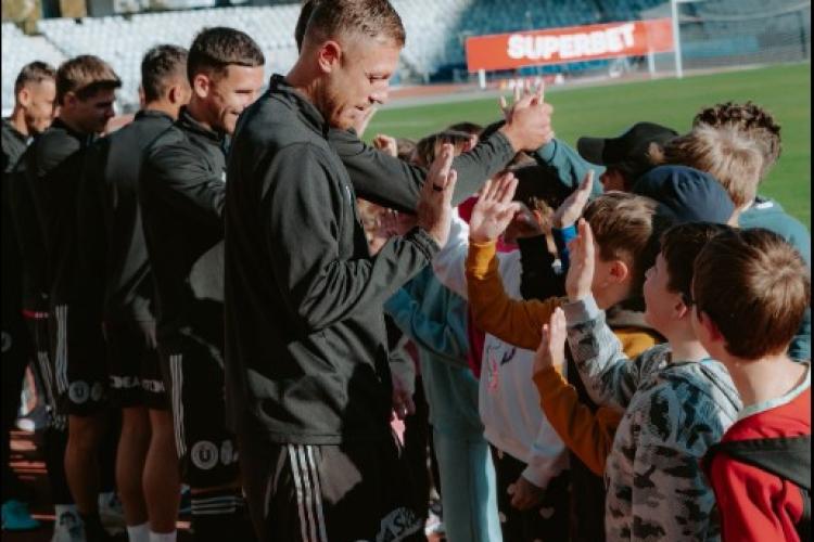 FOTO. Un altfel de antrenament pentru Universitatea Cluj. Jucătorii lui Sabău au primit o vizită surpriză pe stadion. S-a lăsat cu multe autografe 